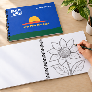 Lifestyle illustration showing a hand drawing a large flower on the open Bold Lines Sketchpad beside its blue cover