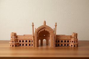 A small wooden architectural model of Rumi Darwaja, Lucknow a domed palace or mosque with minarets, displayed on a wooden table in an indoor room.
