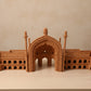 A miniature architectural model of a historic palace Rumi Darwaja with a central arch, displayed on a white tabletop.
