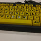 Yellow keyboard with black lettering on a white surface