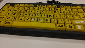 Yellow keyboard with black lettering on a white surface